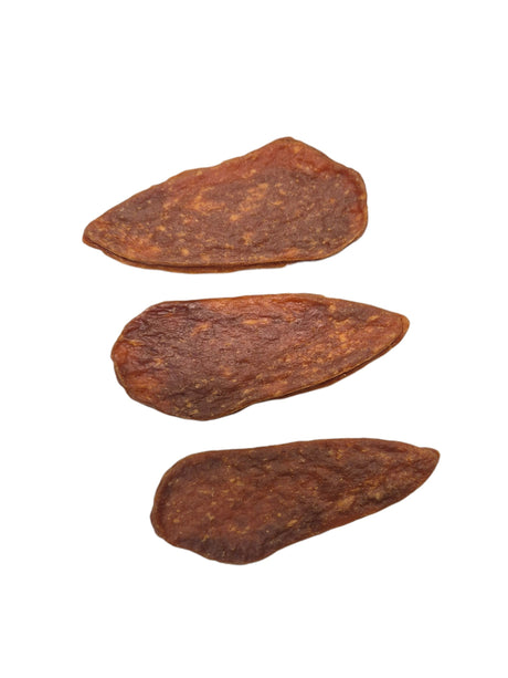 Drei getrocknete Fleischstreifen von gourmetpfoten.de als naturbelassener und gesunder Kausnack für Hunde.