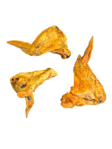 Drei getrocknete gourmetpfoten.de Hühnerflügel als natürlicher, proteinreicher Kausnack für Hunde auf weißem Grund.