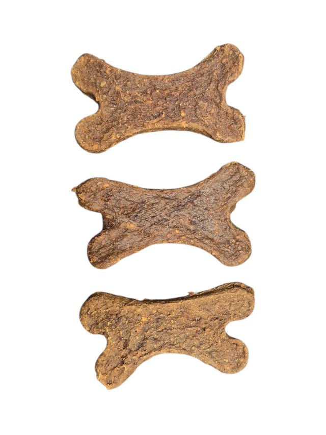 Drei knusprige gourmetpfoten.de Hundesnacks in brauner Knochenform auf weißem Hintergrund