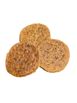 Drei runde, goldbraune Vollkorn-Hundekekse von gourmetpfoten.de mit rustikaler, körniger Textur auf weißem Grund.