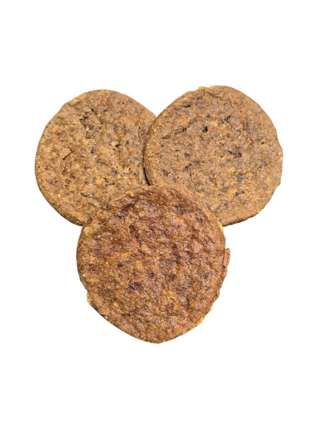Drei runde, goldbraune Vollkorn-Hundekekse von gourmetpfoten.de mit rustikaler Textur als gesunde Belohnung.